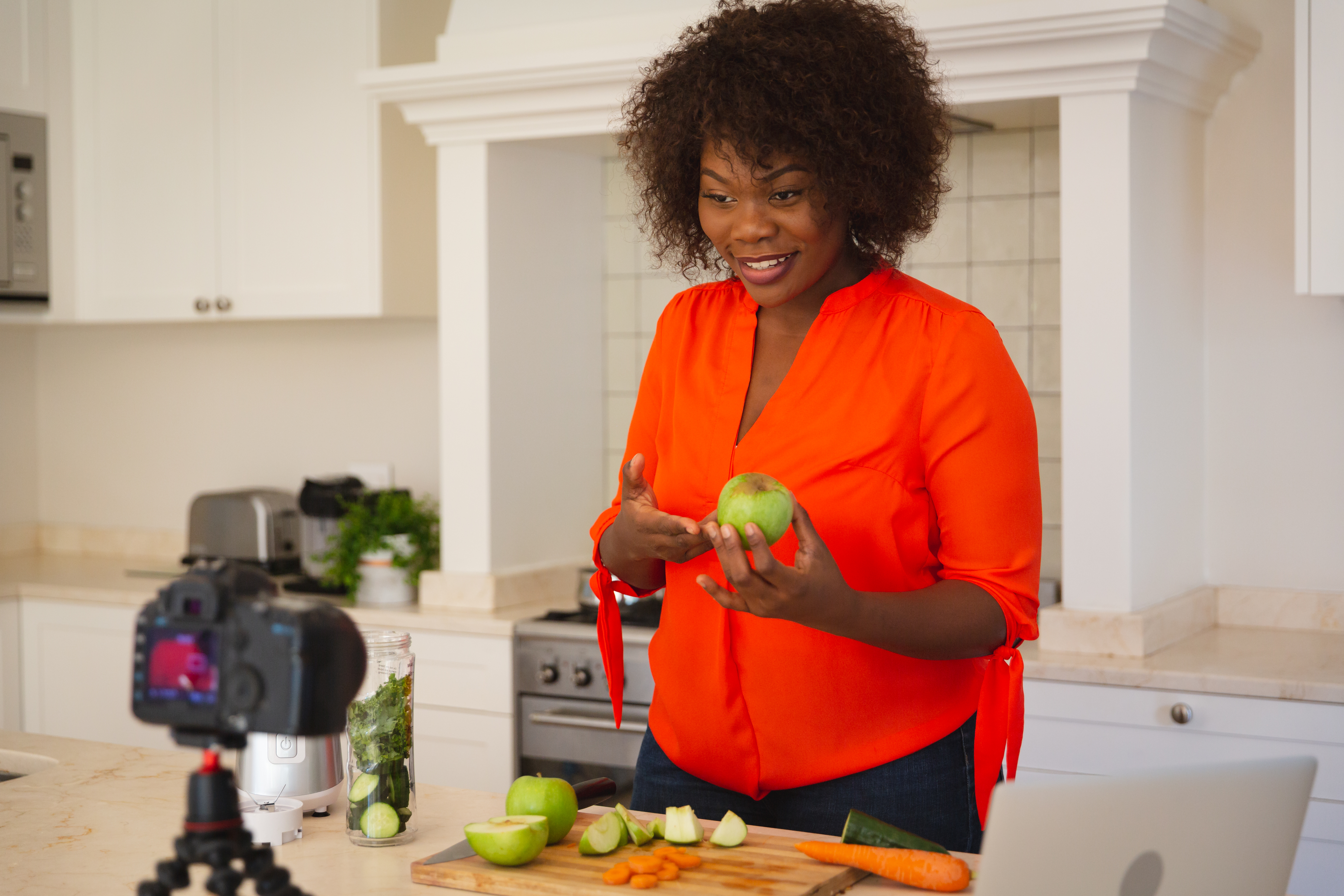 Photo of a woman demonstrating a recipe on camera to a virtual audience