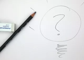 Photo of a pencil and eraser over a drawing of a question mark