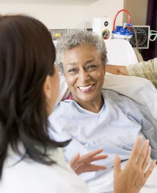 Doctor speaking with a smiling woman and her partner post surgery
